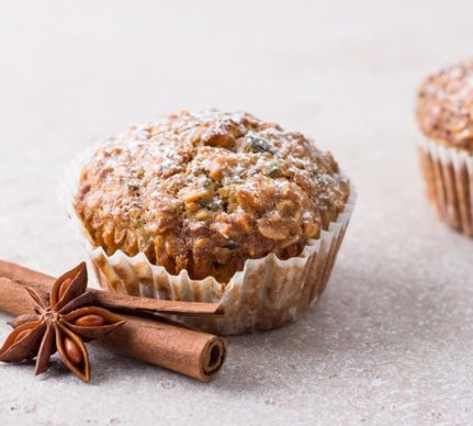Doi muffins cu dovleac și fulgi de ovăz alături de un baton de scorțișoară și o steluță de anason