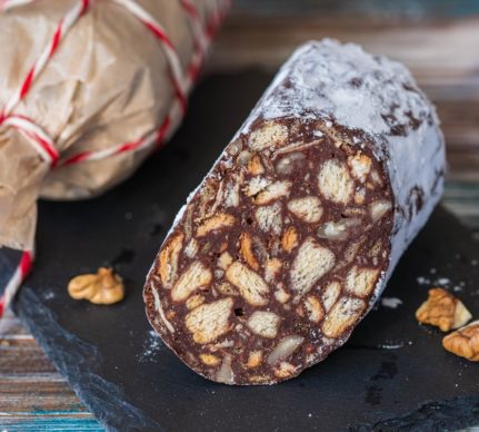 Salam de biscuiți de post secționat pe un platou negru de ardezie